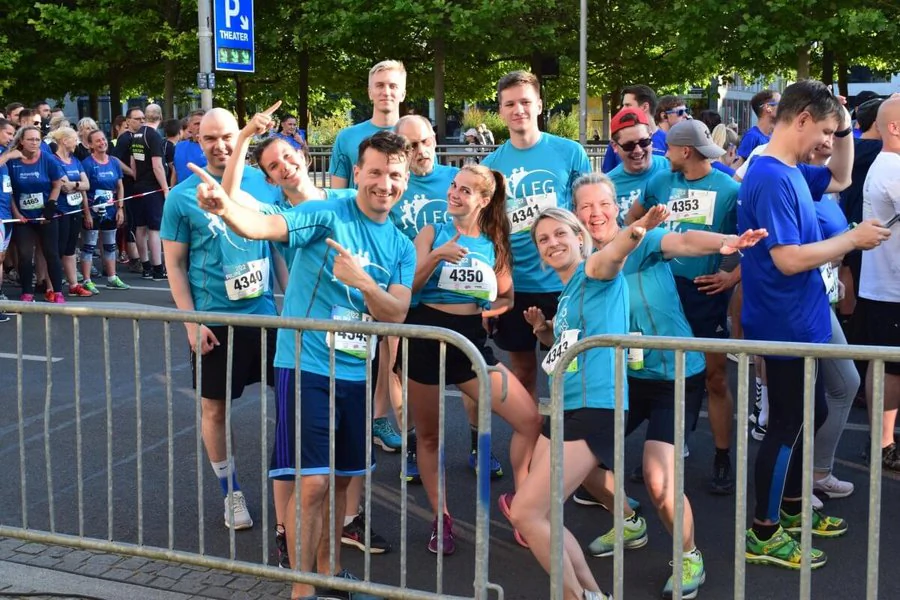 Teilnehmer eines Rennens stehen zusammen und lächeln für ein Gruppenfoto, um den Moment festzuhalten.