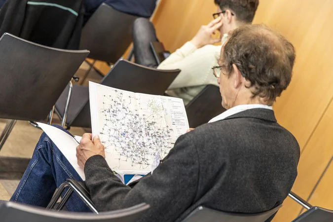 Eine sitzende Person schaut sich den integralen Taktfahrplan an