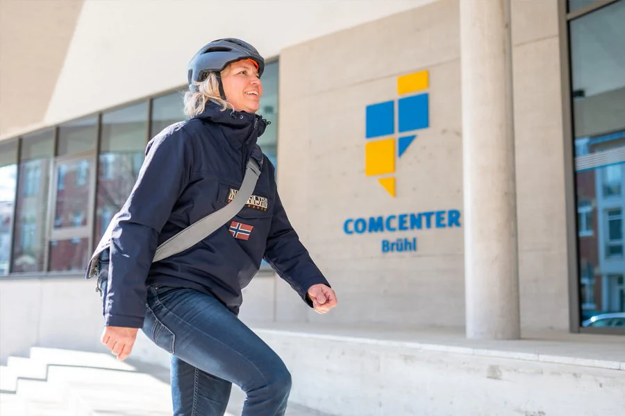 Eine Frau mit Helm ist sicher und selbstbewusst auf dem Weg ins COMCENTER