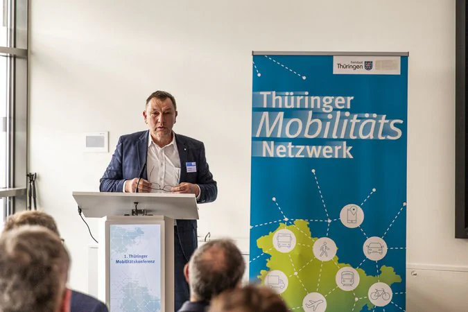 Eine männliche Person hält eine Rede auf einer Konferenz