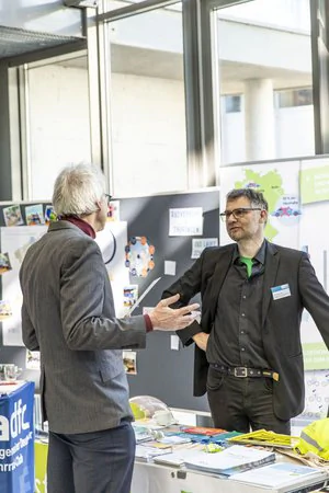Sachlicher Austausch von zwei männlichen Personen am Messestand