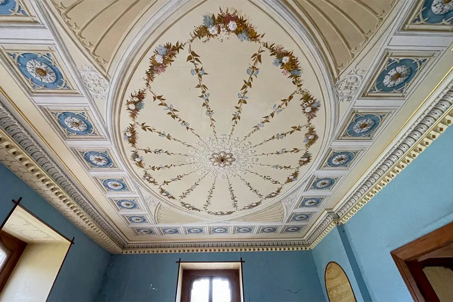 Verzierte Decke eines Innenraumes vom Schloss Reinhardsbrunn, blaue Wände und Fenster mit Lichteinfall