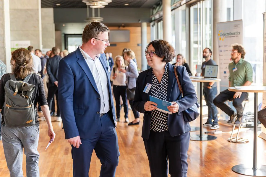 Foto: Robert Weigelt (LEG) und eine Frau tauschen sich auf der Veranstaltung aus