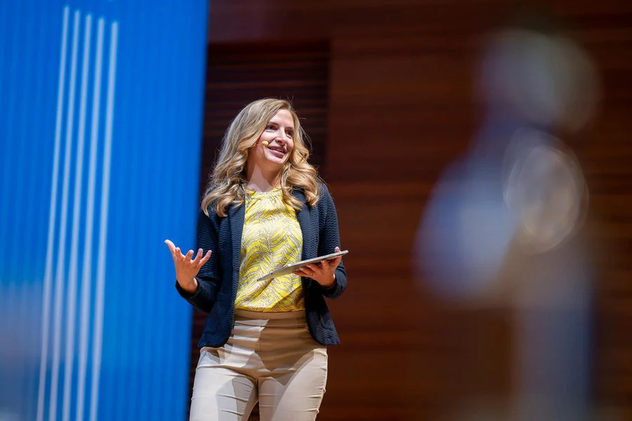Eine Frau hält eine Rede am Podium.