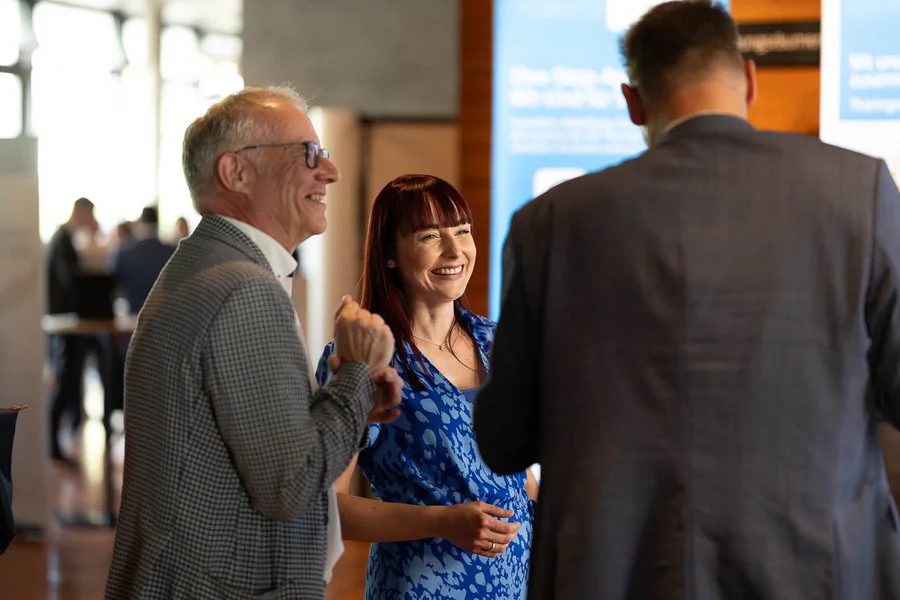Foto: drei Personen unterhalten sich fröhlich auf der Veranstaltung