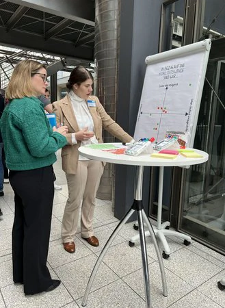 Zwei Frauen diskutieren an einem Flipchart ihre Ansichten