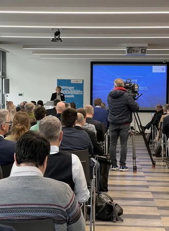 Kamera-Team filmt Frau Wosche während ihrer Rede auf einer Konferenz