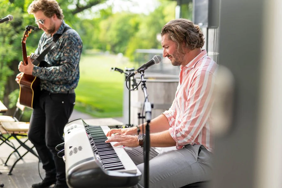 Zwei Männer musizieren zusammen auf einem Keyboard und einer Gitarre