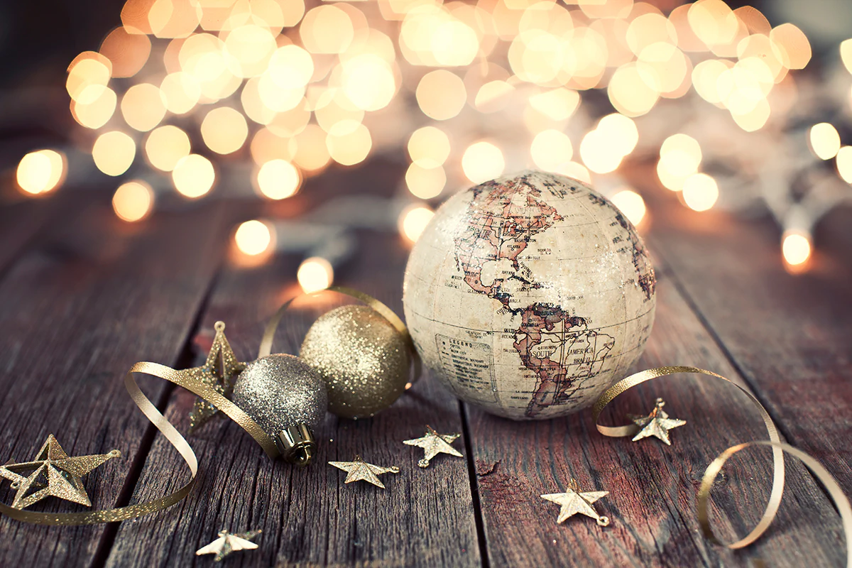 Rückblick 2025. Bild: Liliboas / istockphoto.com Weihnachtskugel, Lichter, Kugeln und Dekorationen auf altem Holzhintergrund mit Weihnachtsbeleuchtung
