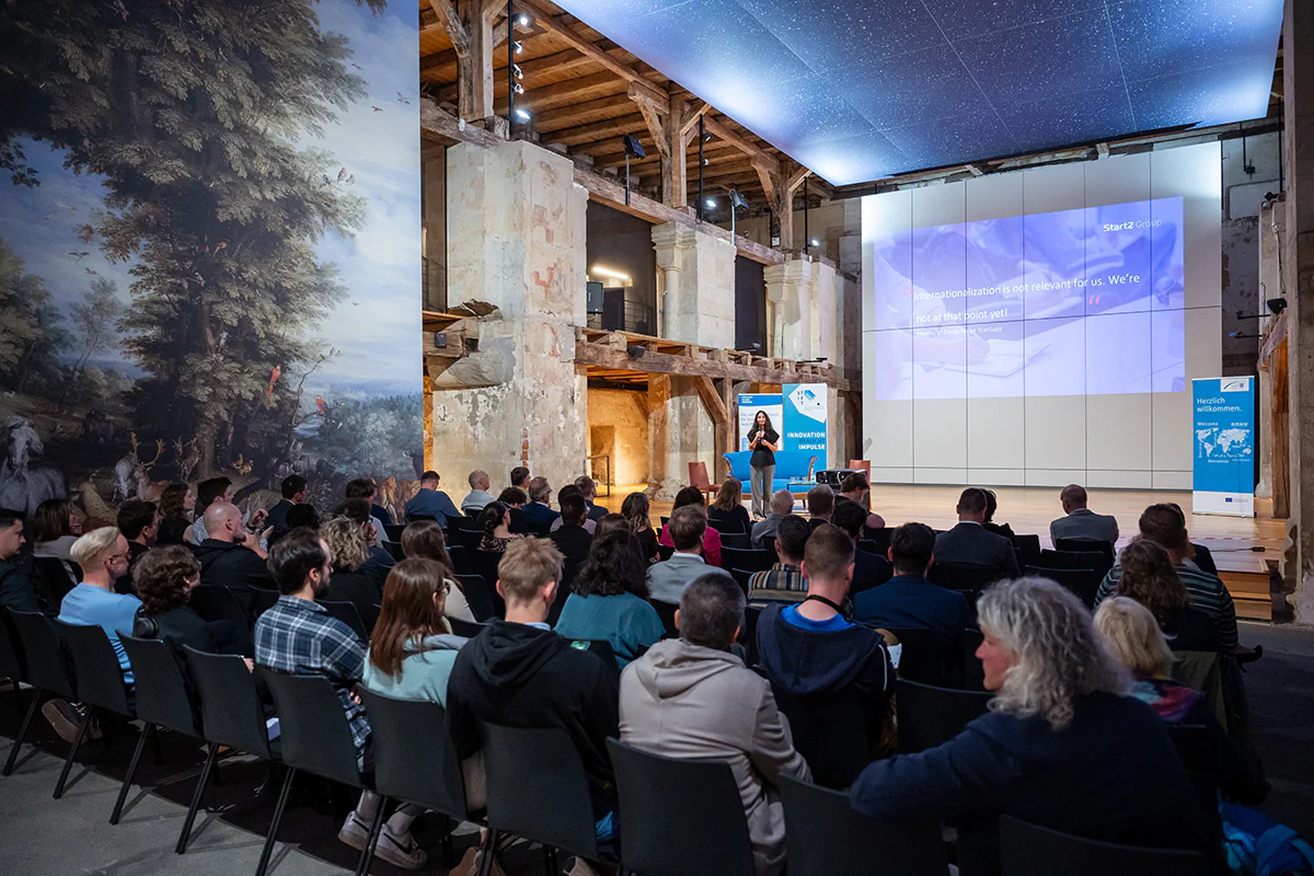Speaker auf einer Bühne vor Publikum