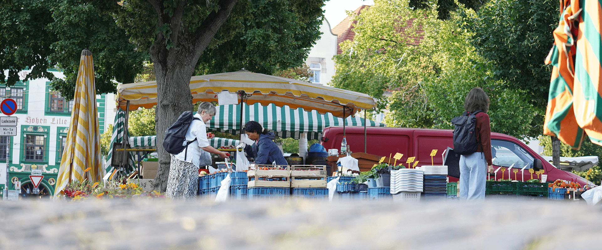 Bildbeschreibung / description: Menschen unterhalten sich an einem Marktstand in Erfurt an einem sonnigen Tag im Schatten