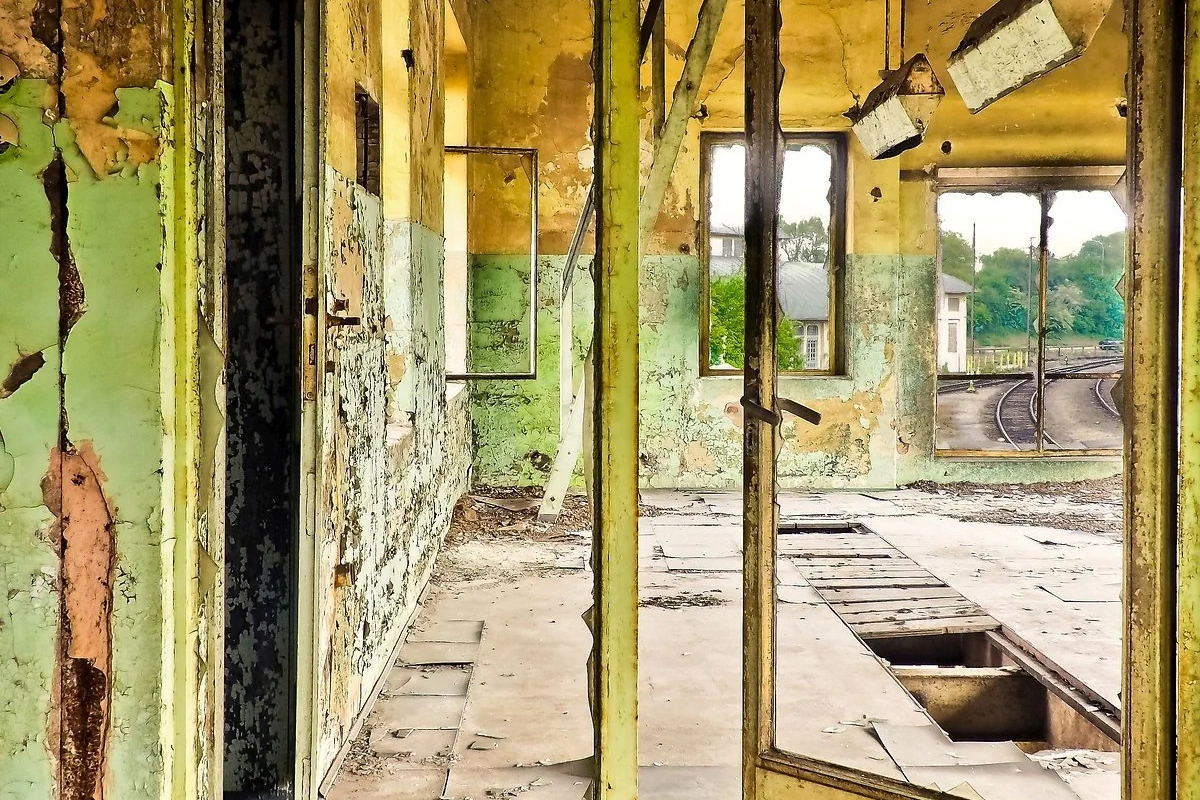 Brachflächenkataster Bildbeschreibung / description: Verfallener Bahnhof mit beschädigten Fenstern und buntem Graffiti, das die Geschichte des Ortes erzählt.